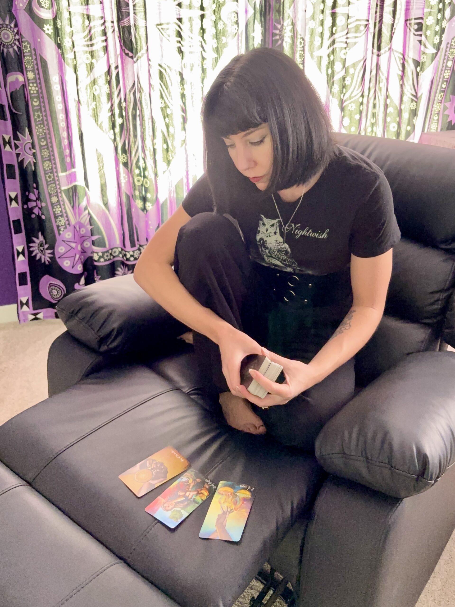 Woman sitting in a recliner reading tarot cards