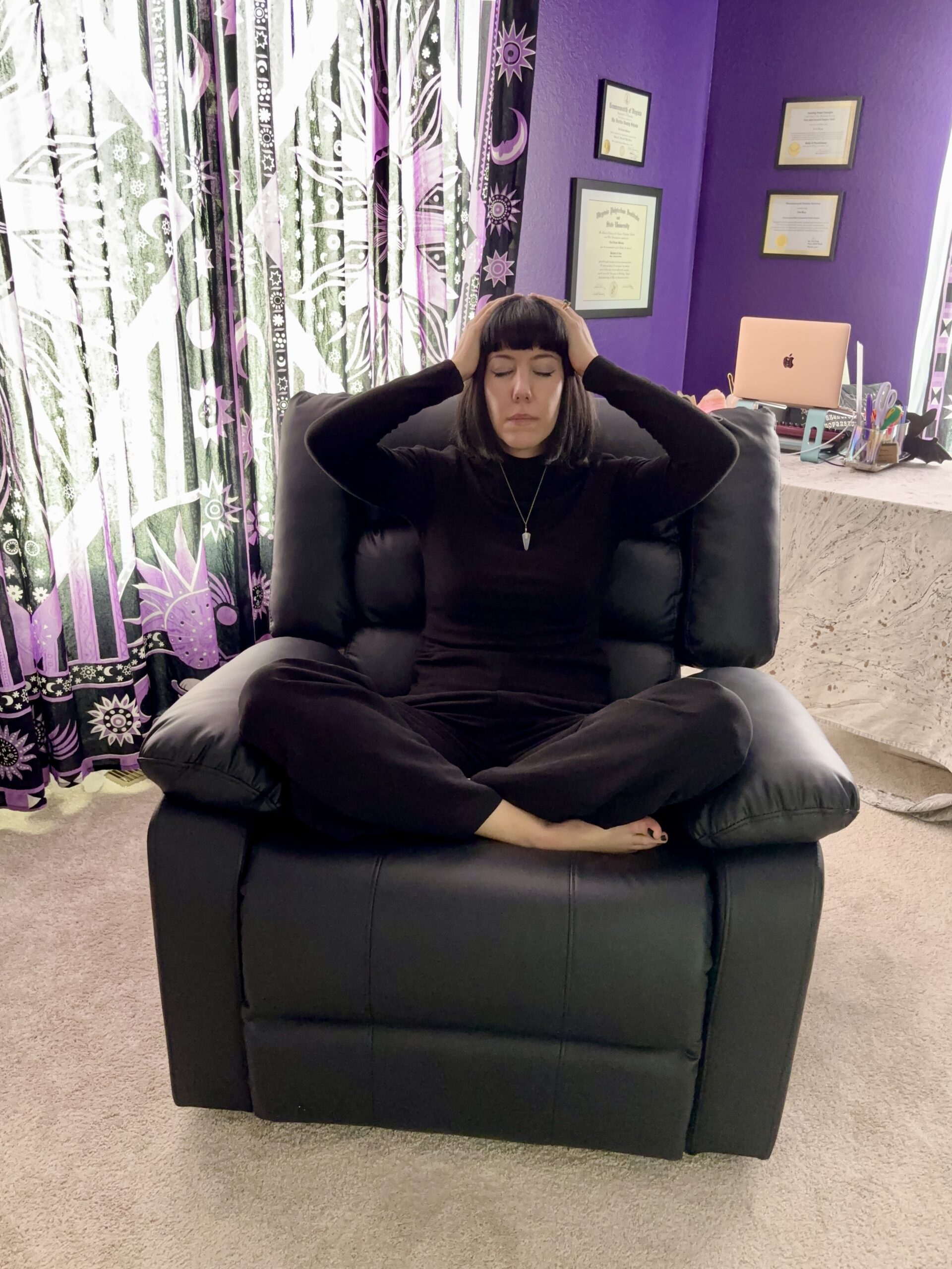 Woman sitting in a recliner performing self-Reiki
